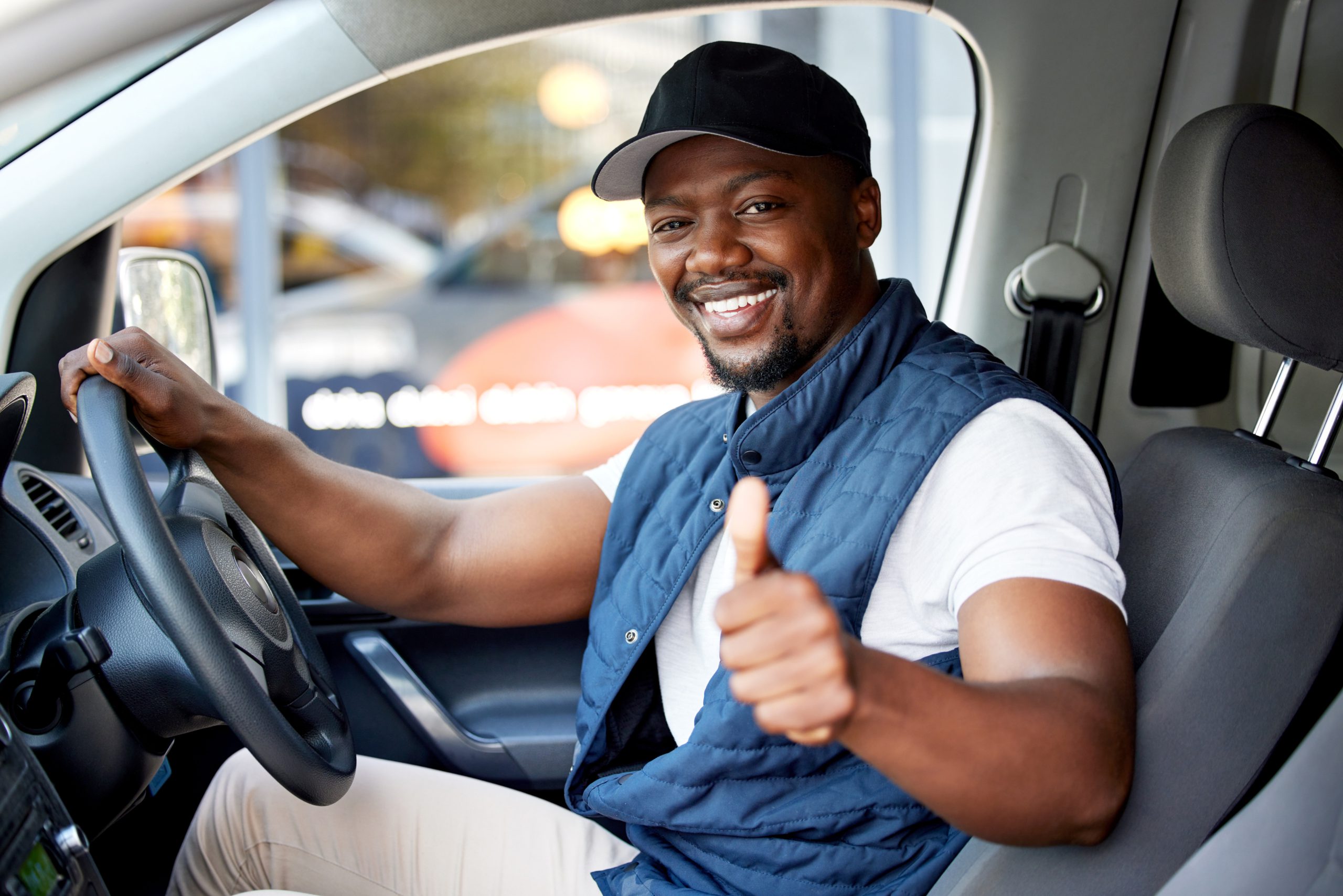 Delivery guy, transport or man driving with thumbs up, shipping or courier service. Happy black person, portrait or driver for like, support emoji or hand sign in van, cargo vehicle or transportation.